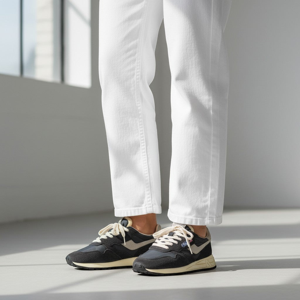 Sneaker Autry Reelwind negra de ante y nylon con cordones blancos y suela de goma beige. Estilo retro running.