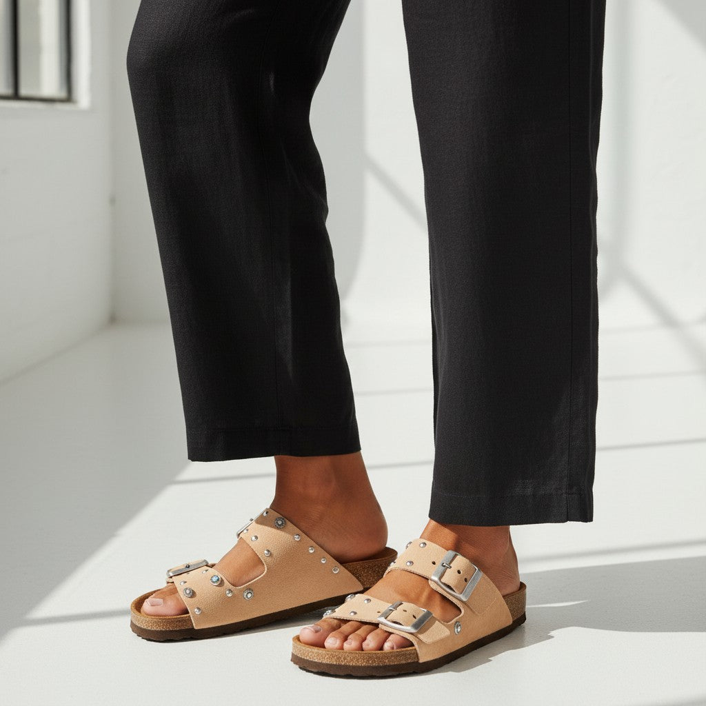 Sandalia Post & Co beige de ante con tachuelas plateadas y detalles de turquesa, con dos hebillas metálicas.